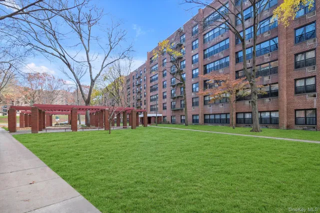 a view of a big building with a big yard and large trees