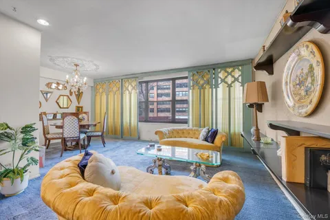 a living room with furniture a fireplace and a large window