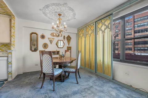 a view of a dining room with furniture and chandelier