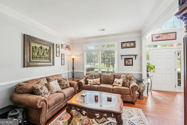 a living room with furniture and painting on the wall