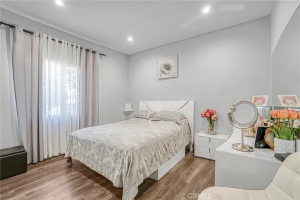 a bedroom with a bed flowerpot and wooden floor