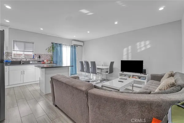 a room with stainless steel appliances kitchen island granite countertop a sink and cabinets