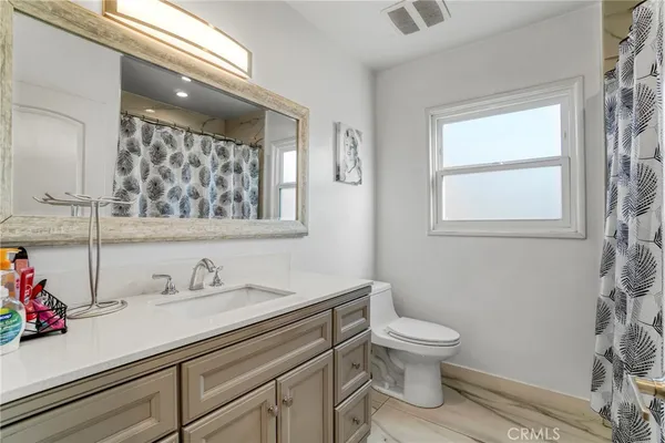 a bathroom with a sink a toilet and a window