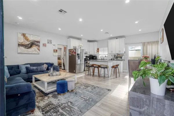 a living room with furniture and a dining table with kitchen view