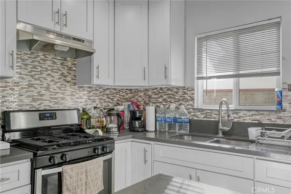 a kitchen with stainless steel appliances granite countertop a sink stove and cabinets
