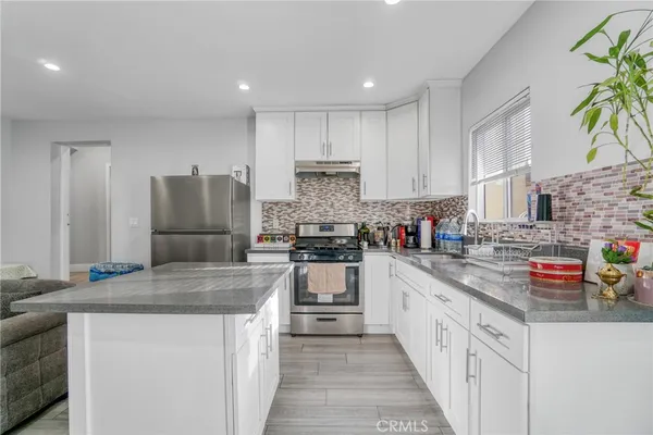 a kitchen with stainless steel appliances granite countertop a refrigerator and a stove