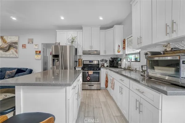 a kitchen with stainless steel appliances granite countertop a stove a sink and a refrigerator