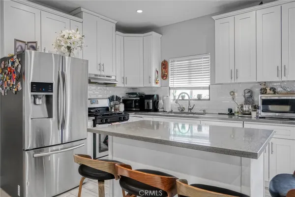 a kitchen with stainless steel appliances granite countertop a refrigerator sink and cabinets