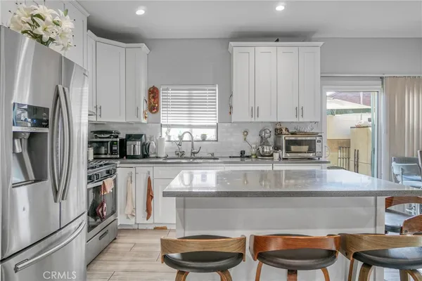 a kitchen with stainless steel appliances granite countertop a refrigerator sink and stove