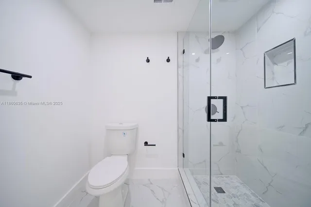 a white toilet sitting next to a bathroom sink
