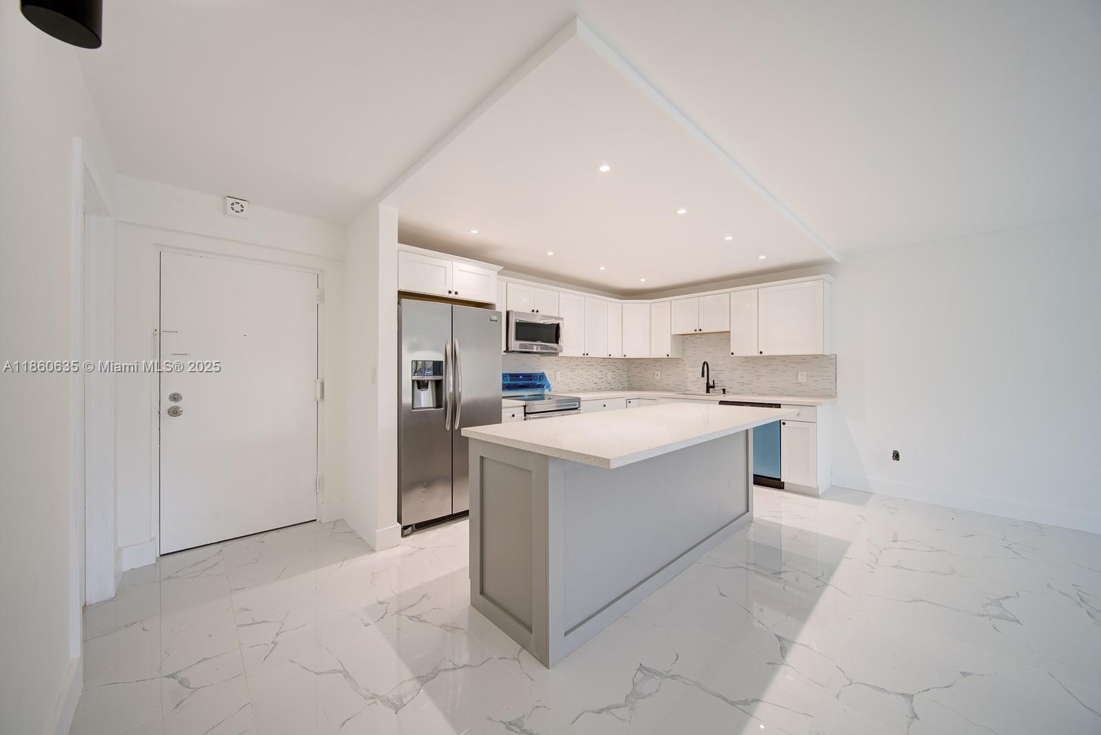 14850 Naranja Lakes Boulevard, Unit B1P Homestead, FL 33032 - Photo 2 of 21 a large white kitchen with a stove top oven a refrigerator and white cabinets