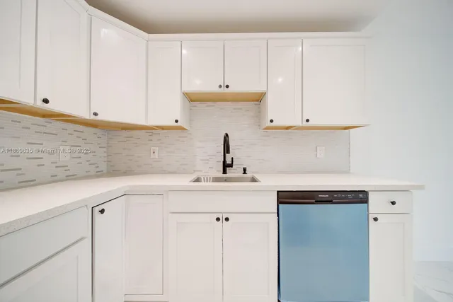a kitchen with white cabinets and a sink