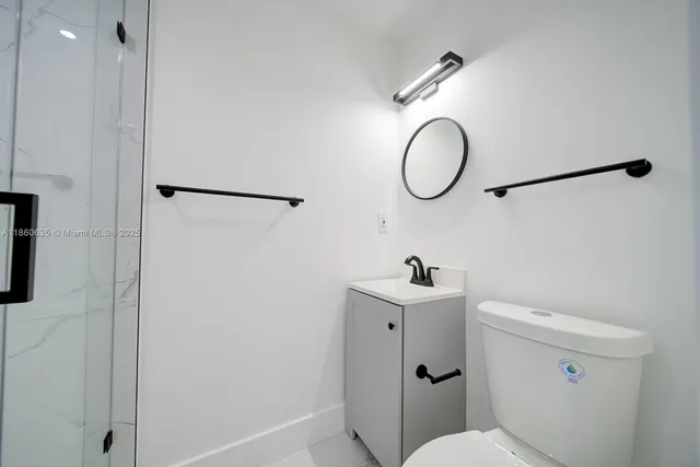 a bathroom with a toilet sink vanity and mirror
