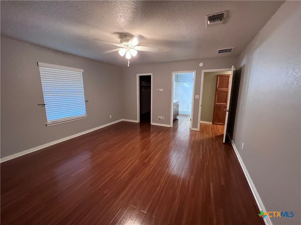 1241 Rapids Road New Braunfels, TX 78130 - Photo 18 of 27 an empty room with wooden floor and windows