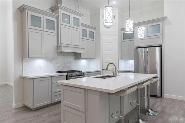 a kitchen with stainless steel appliances granite countertop a sink a stove and cabinets