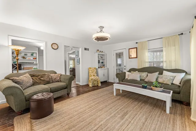 a living room with furniture wooden floor and window