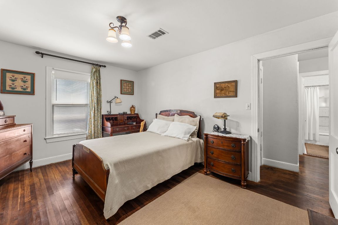 1303 Alegria Road Austin, TX 78757 - Photo 14 of 25 a spacious bedroom with a bed and a chandelier
