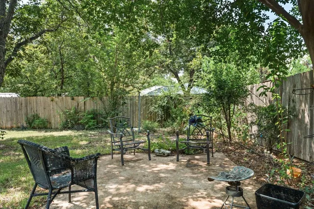 a view of a chairs and table in the backyard