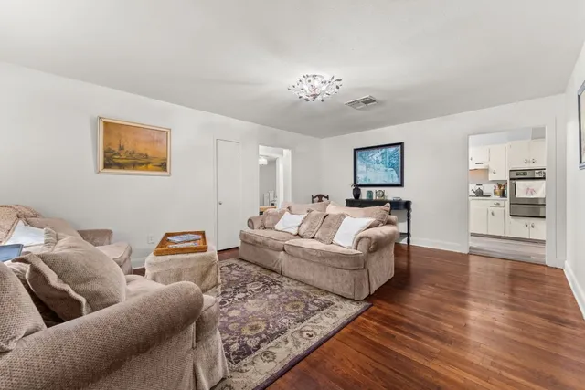 a living room with furniture and wooden floor