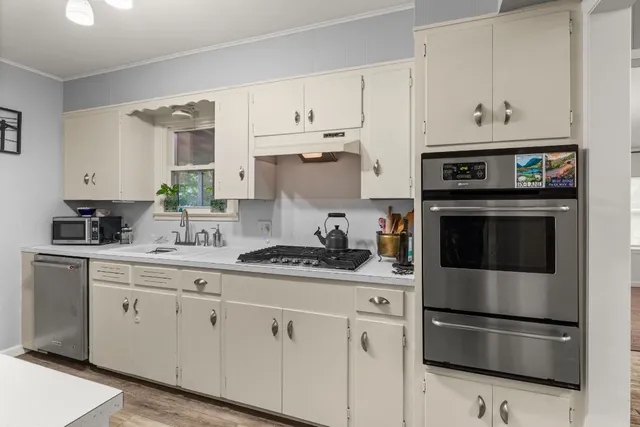 a kitchen with cabinets stainless steel appliances and a counter space