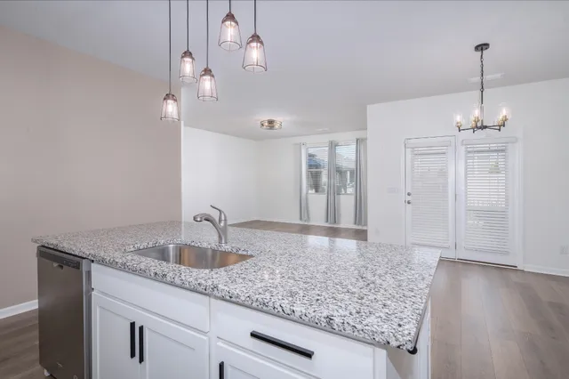 a bathroom with a granite countertop sink a mirror and shower