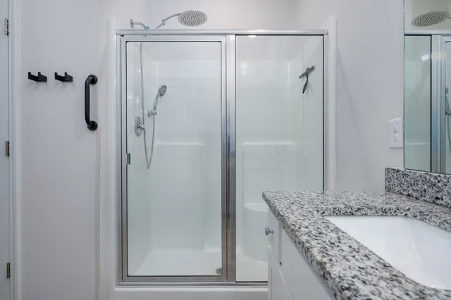 a bathroom with a granite countertop shower mirror and a sink