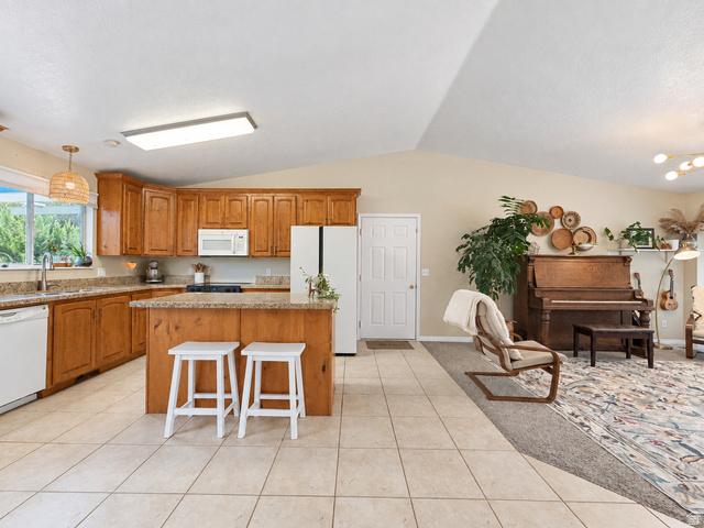 Kitchen featuring wood-finish cabinetry, light-toned countertops, and an integrated kitchen island
