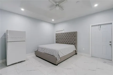 a room with a bed and a refrigerator