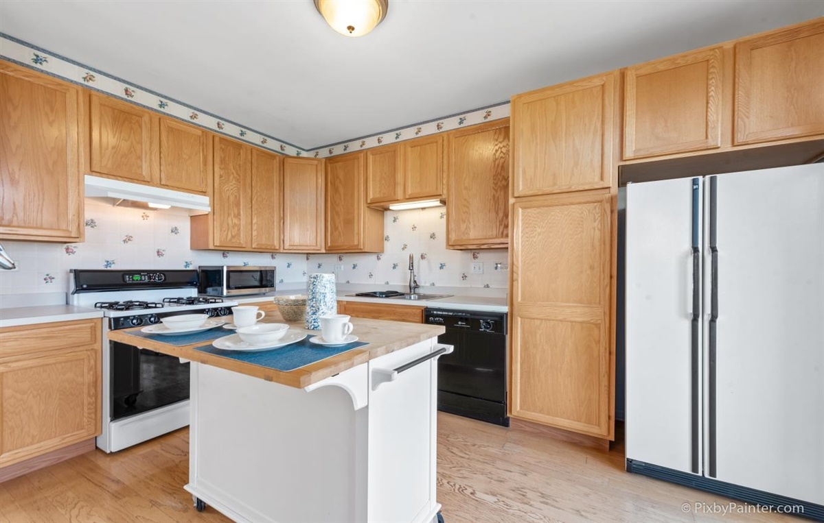 243 Grand Ridge Road St. Charles, IL 60175 - Photo 12 of 29 a kitchen with stainless steel appliances granite countertop a stove a refrigerator a sink dishwasher and white cabinets with wooden floor