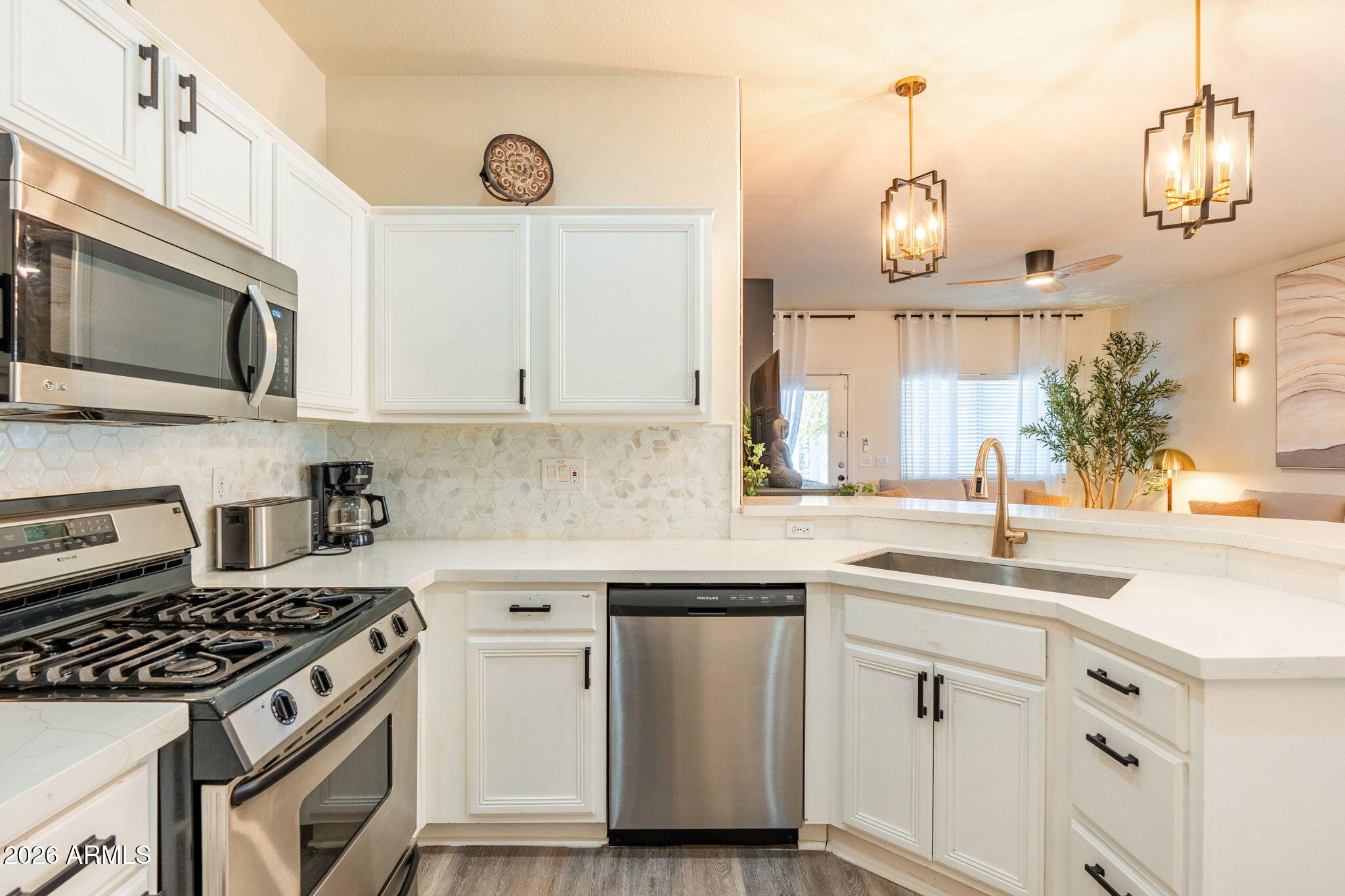 3674 South Joshua Tree Lane Gilbert, AZ 85297 - Photo 10 of 30 a kitchen with cabinets stainless steel appliances and wooden floor