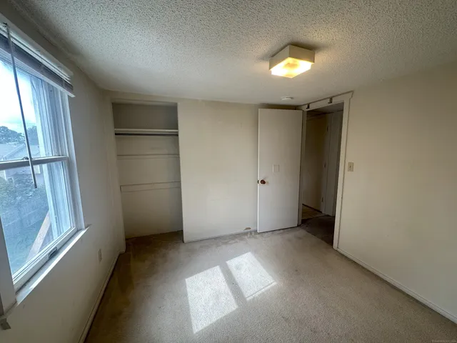 an empty room with windows and closet