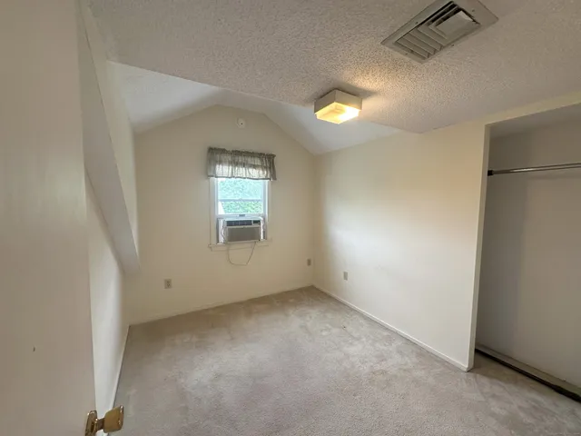an empty room with windows and closet