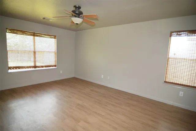 an empty room with a window and wooden floor