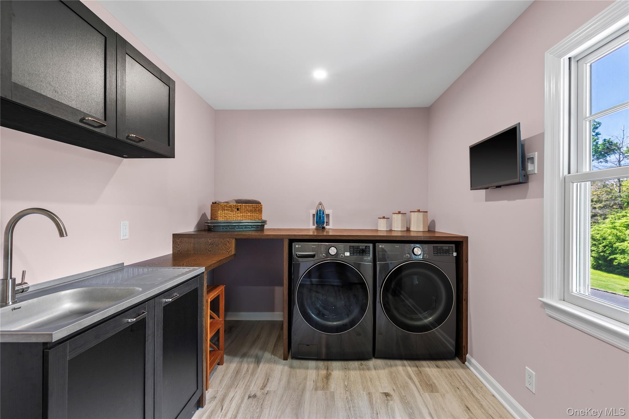 19 John Jay Place Rye, NY 10580 - Photo 37 of 45 This gorgeous laundry room boasts high-end washer and dryer, a sink, a folding shelf, cabinets, and a full closet for cleaning equipment.