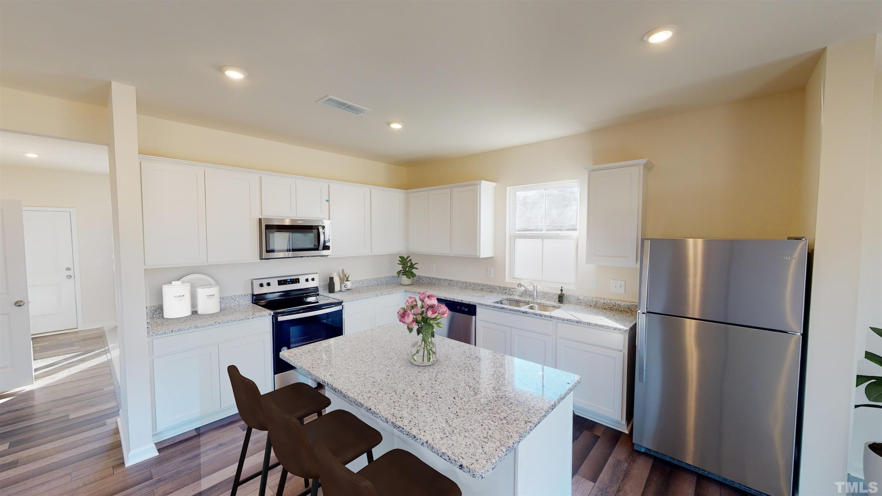 3517 Dragonfly River Raleigh, NC 27604 - Photo 9 of 27 a kitchen with stainless steel appliances granite countertop a refrigerator a stove a sink a dining table and chairs
