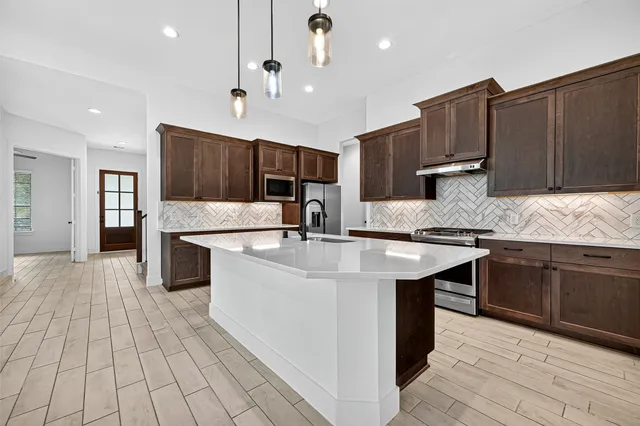 a kitchen with stainless steel appliances granite countertop a sink stove and cabinets