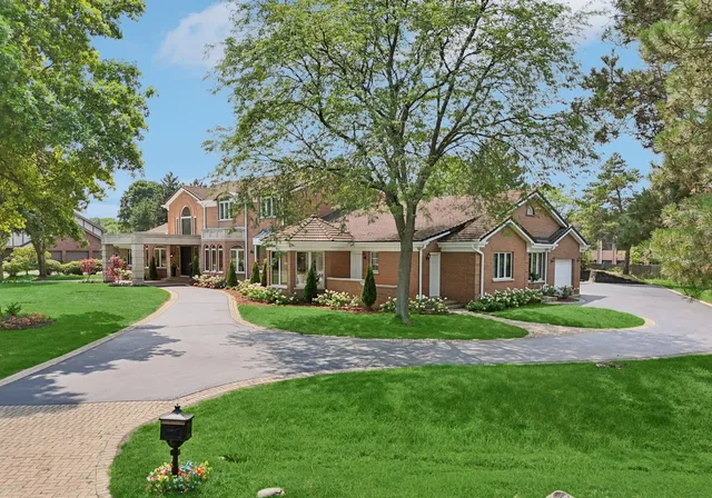a front view of a house with a garden and trees
