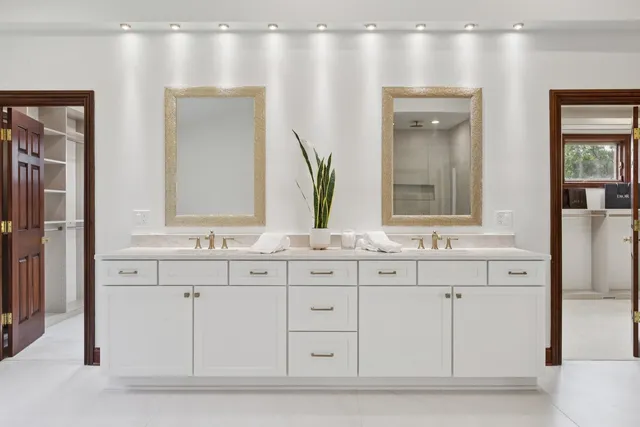 a view of a patio with a dining table and chairs under an umbrella with a garden