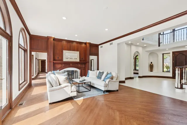 a living room with furniture a fireplace and a floor to ceiling window