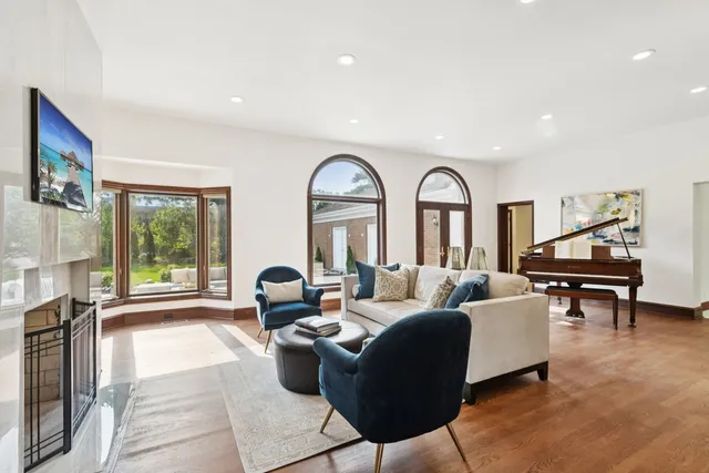 a living room with furniture flowers and wooden floor