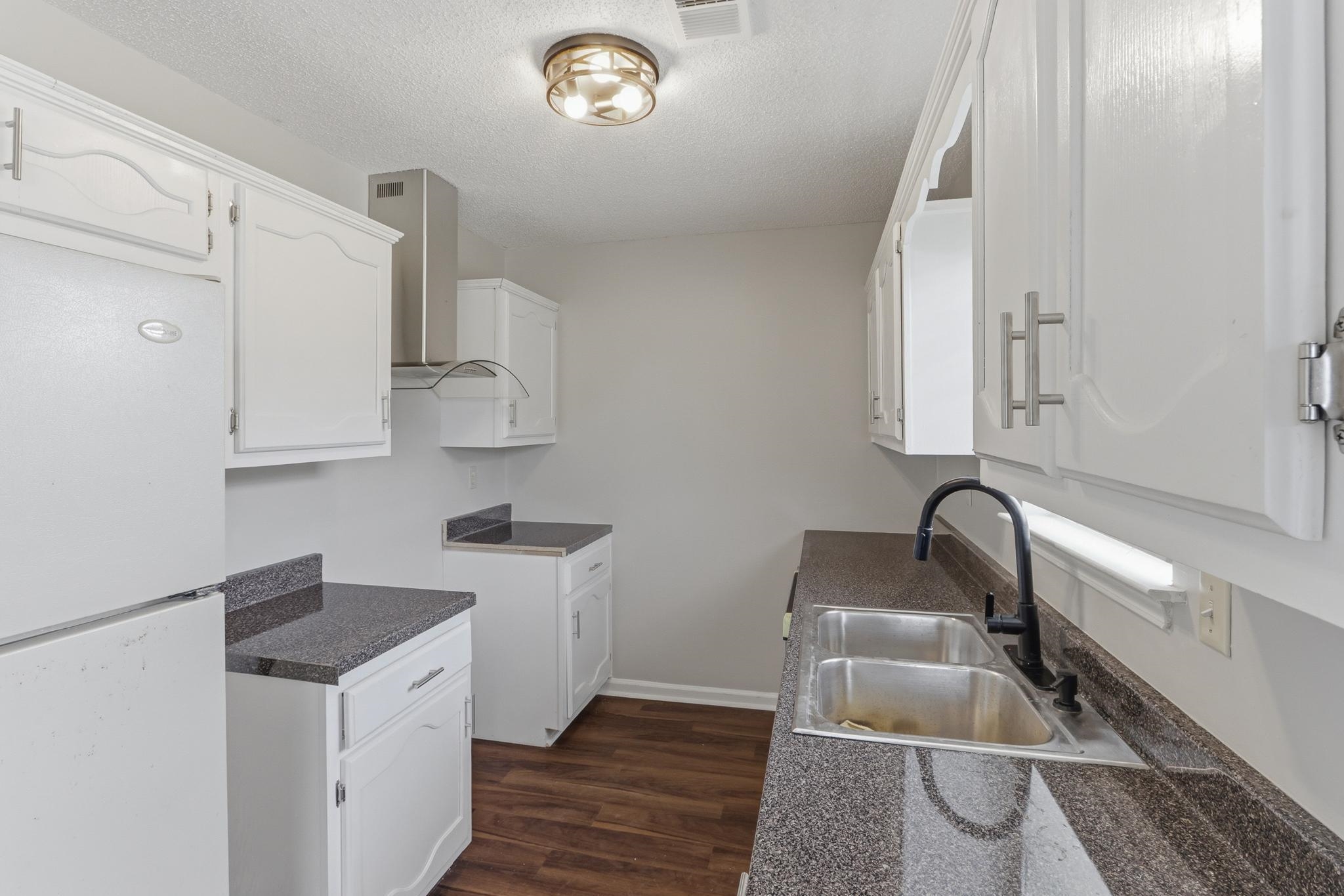 4101 Long Creek Road Memphis, TN 38125 - Photo 5 of 36 Kitchen featuring white cabinetry, dark speckled countertops, and wood-finish flooring