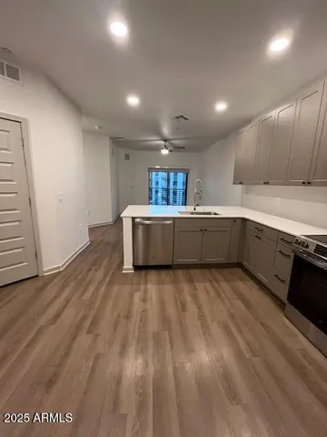 a large kitchen with wooden floors and stainless steel appliances