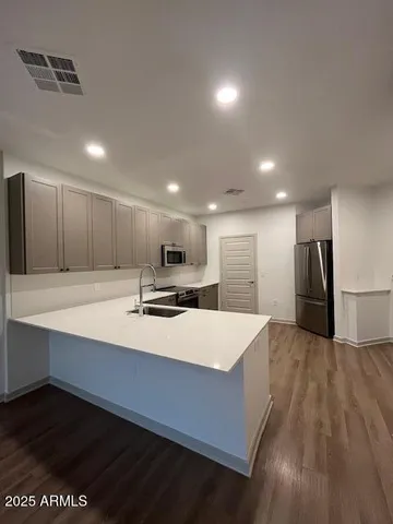 a large kitchen with kitchen island a sink stainless steel appliances and cabinets