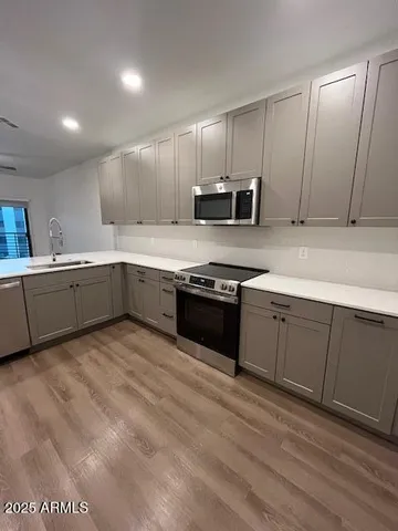 a kitchen with stainless steel appliances granite countertop a stove a sink and a microwave