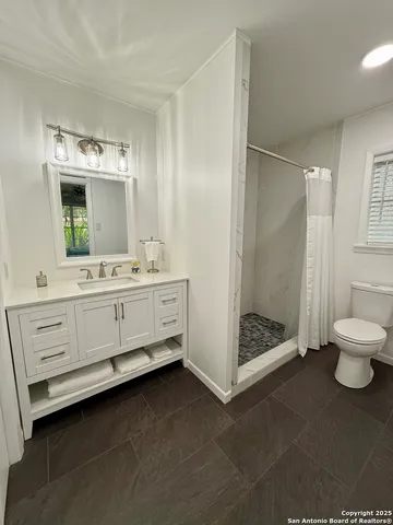 a bathroom with a double vanity sink mirror and toilet