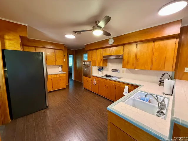 a kitchen with sink refrigerator and cabinets