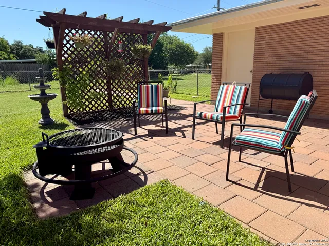 a view of a patio with a table chairs and a garden