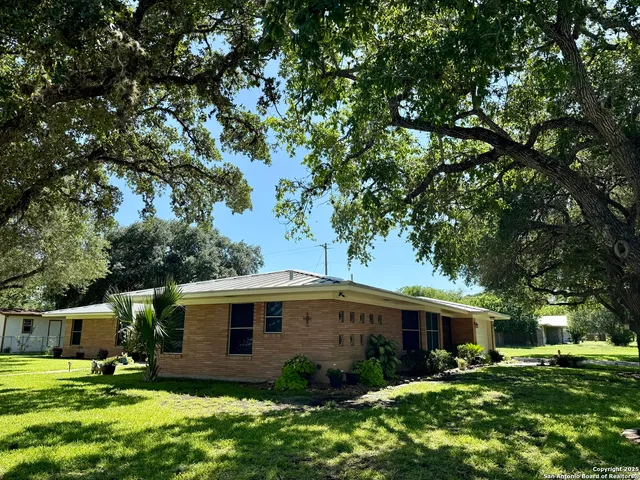 a front view of house with yard and trees