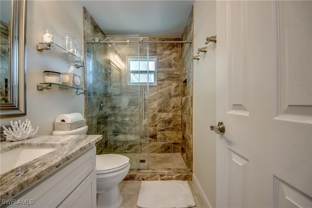 a bathroom with a granite countertop sink toilet and shower