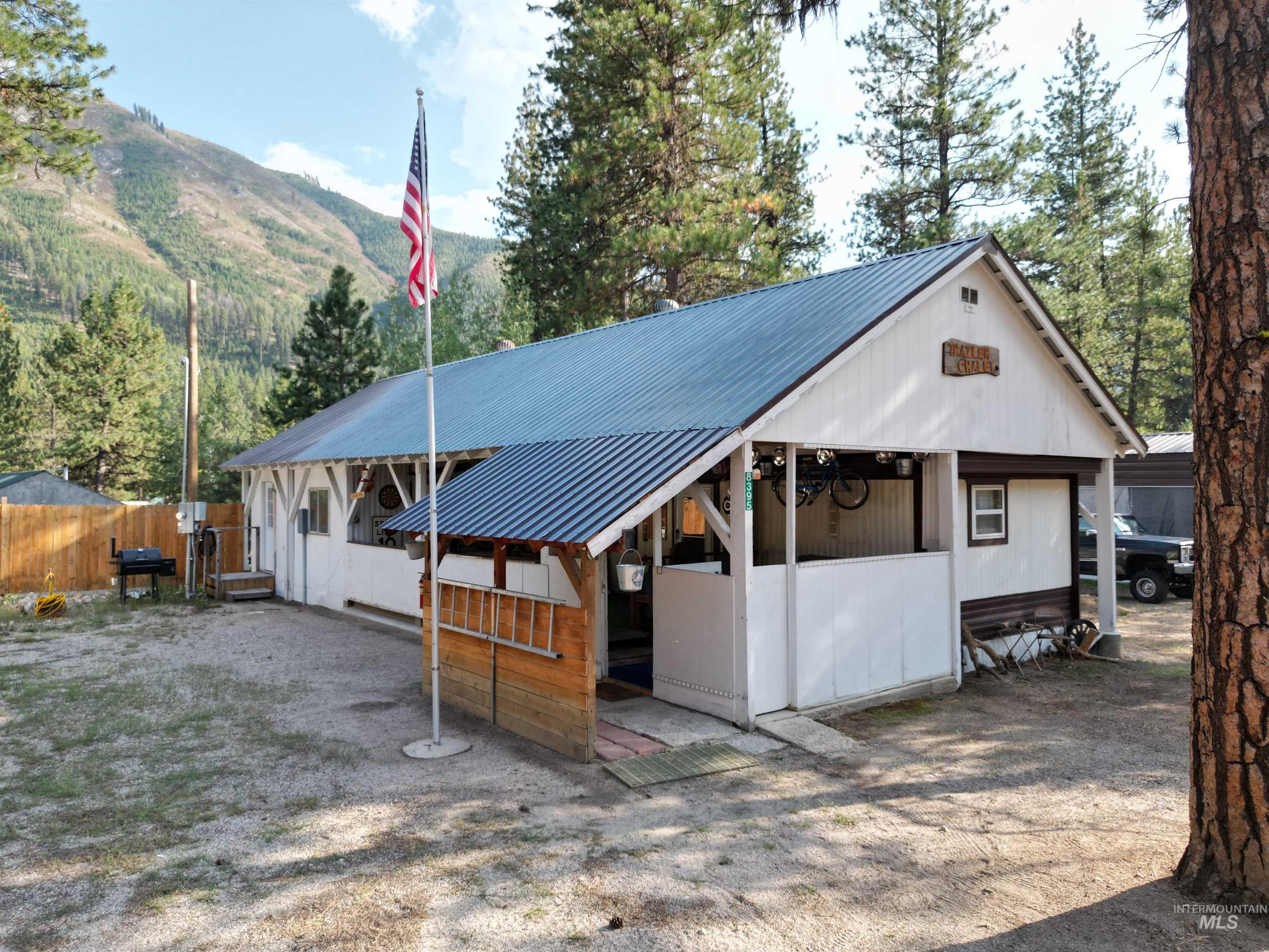 View of front of property with a metal roof, an exterior structure, a mountain view, and an outdoor structure
